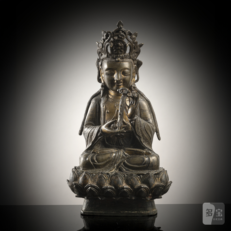 A bronze model of Guanyin on a lotus, holding a sceptre in his hands